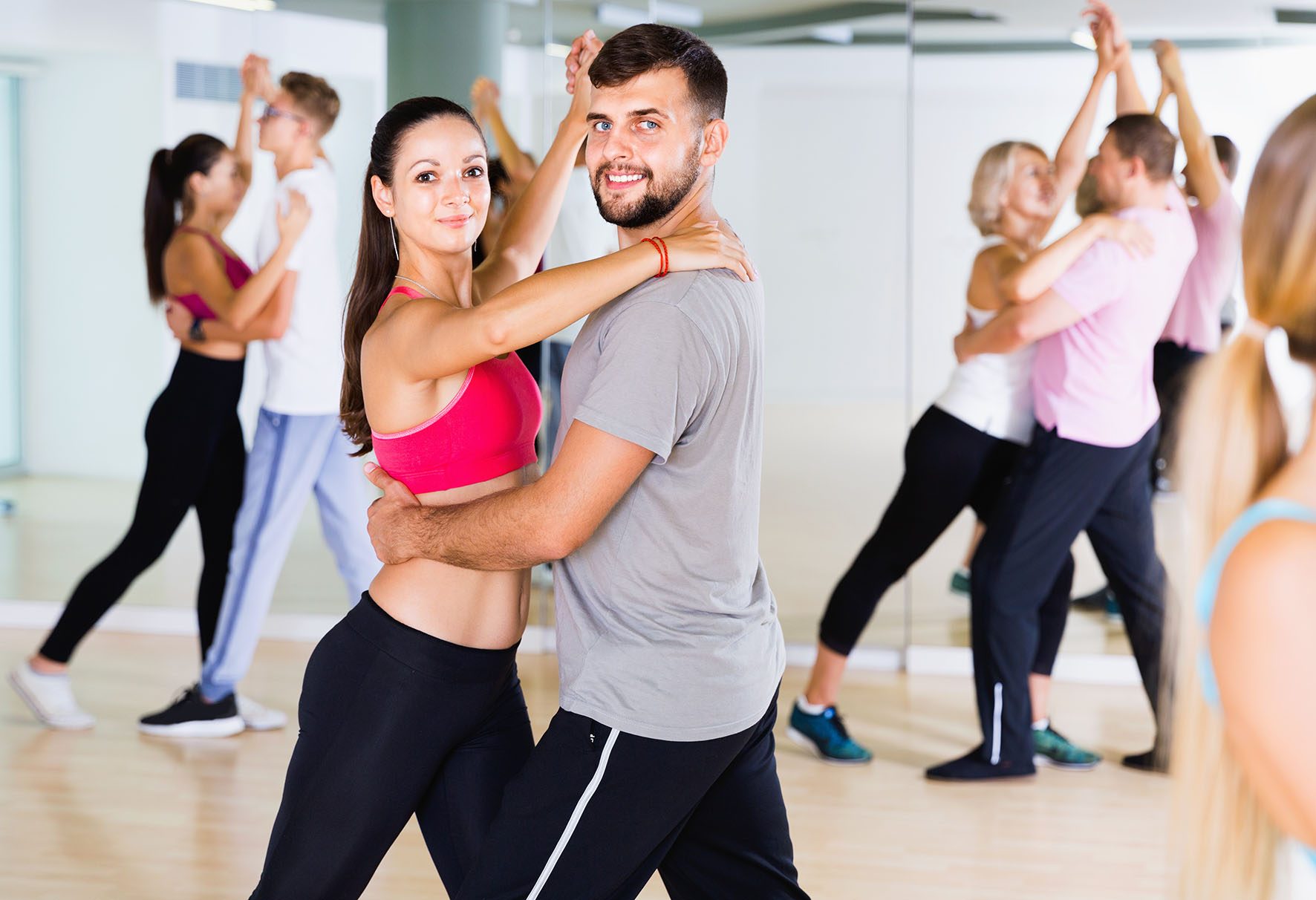 Group of young adults dancing salsa in club
